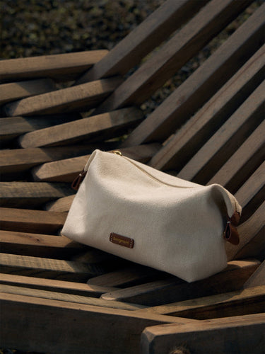 Songmont canvas storage bag with leather trim and logo, ideal for makeup and essentials.