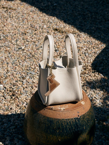 Songmont Puppy Charm: Textured cream leather tote bag with dog silhouette charm