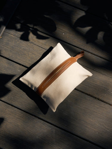 Songmont canvas tissue box cover with tan leather strap on wood, dappled sunlight.