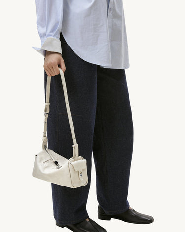 Mini Yore Camera Bag in Cloud color, crafted from vegetable-tanned leather with unique tiger-tooth buckle detail.