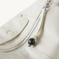 Mini Yore Camera Bag in Cloud color, featuring vegetable-tanned leather, silver zipper, and ebony wood detail.