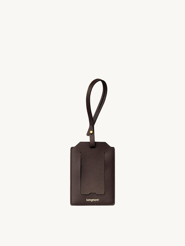 Brown leather Songmont luggage tag with strap and clear card slot.