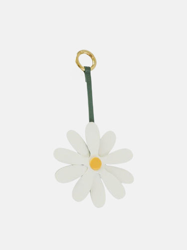 White leather daisy charm with yellow center and green strap on a gold ring