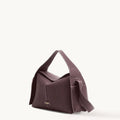 Drippy Roof Bag in burgundy full-grain leather with white stitching and gold logo.
