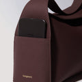 Burgundy leather Drippy Roof Bag with iPhone in exterior pocket and gold Songmont logo.