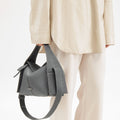 Drippy Roof Bag in stardust grey textured leather, styled with an oversized beige shirt and trousers.