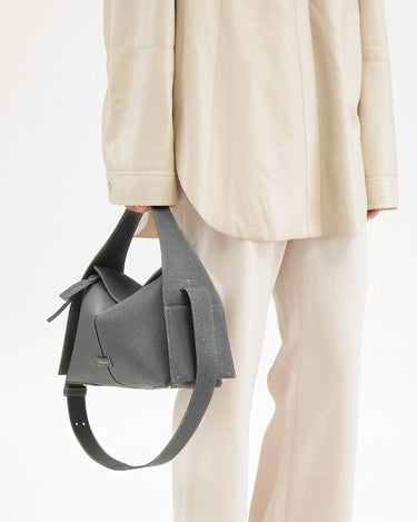 Drippy Roof Bag in stardust grey textured leather, styled with an oversized beige shirt and trousers.