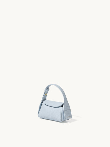 Light blue pebbled leather Mini Drippy AirPods Case with a short handle and a snap closure.