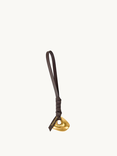Faith Stone Charm accessory with golden abstract charm and dark leather strap, featuring 'Songmont' logo.
