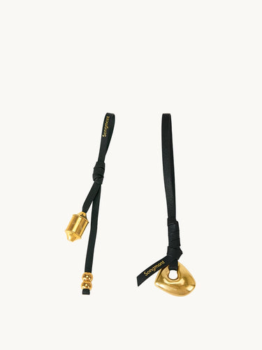 Faith Stone & Prayer Wheel Charm set: gold metal charms on black leather with 'Songmont' logo.