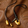 Faith Stone Charm & Prayer Wheel Charm Set in Onyx and Sandal colors with gold hardware on brown leather.