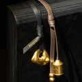 Sandal Faith Stone & Prayer Wheel Charm Set, gold metal charms on black/brown leather straps with Songmont logo.