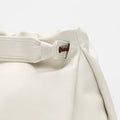 Gather Clutch Set in Cloud: Soft white nappa leather bag with braided detail and adjustable strap.