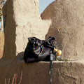 Ebony Gather Clutch Set in full-grain nappa leather with beaded strap and gourd charm.