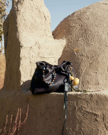 Ebony Gather Clutch Set in full-grain nappa leather with beaded strap and gourd charm.