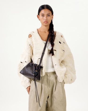 Ebony Gather Clutch Set on model wearing distressed knit cardigan and beige trousers