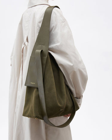 Olive suede large Drippy tote bag with leather strap and "Songmont" logo, worn by a person in a beige trench coat.
