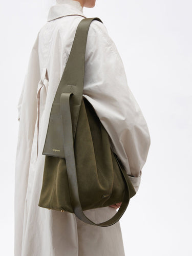 Olive suede large Drippy tote bag with leather strap and "Songmont" logo, worn by a person in a beige trench coat.