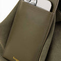 Olive large leather tote bag with an exterior pocket holding a smartphone. Features gold 'Songmont' logo.