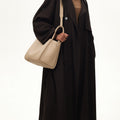 Large Song Bag in Cream Apricot, pebbled leather with adjustable strap and gold hardware.