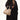 Large Song Bag in cream apricot, pebbled leather with gold feet, held by a model in a brown coat.