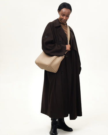 Large Song Bag in cream apricot, textured leather bucket bag with gold hardware and adjustable strap.