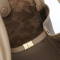 Large Songmont bag in taupe leather. Close-up of interior with suede lining and gold clasp.