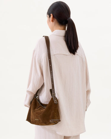 Large Yore Hobo Bag in Sandal Suede, made of cow suede leather and vegetable-tanned leather, worn by a model.