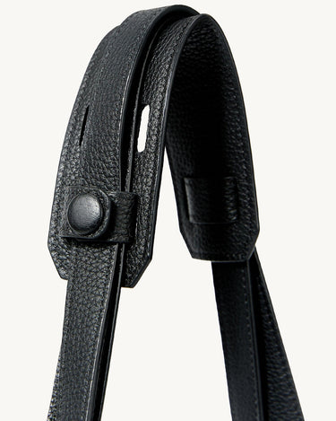 Close-up of the black leather strap and closure mechanism on the Large Yore Tote Bag, showcasing the pebbled texture and stainless steel hardware.