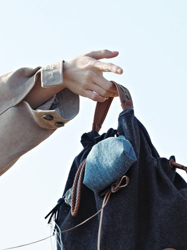 Lucky Pouch Charm bag with leather strap, drawstring closure, and denim accent pouch, made of fabric and leather.