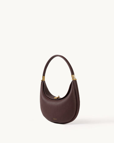 Burgundy leather Luna Bag with gold hardware and adjustable strap, designed for shoulder or crossbody wear.