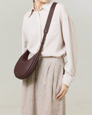 Burgundy Luna Bag crafted from textured leather with adjustable strap, worn by a model.