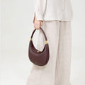 Burgundy Luna Bag with gold hardware, made of textured leather, and an adjustable strap.