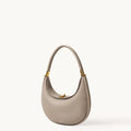 Textured pebble leather Luna Bag in Cobble with gold hardware and a curved top handle.