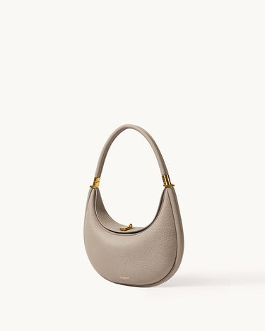 Textured pebble leather Luna Bag in Cobble with gold hardware and a curved top handle.