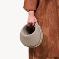Luna Bag in Cobble textured leather, a crescent-shaped crossbody bag with a supple feel, perfect for everyday use.