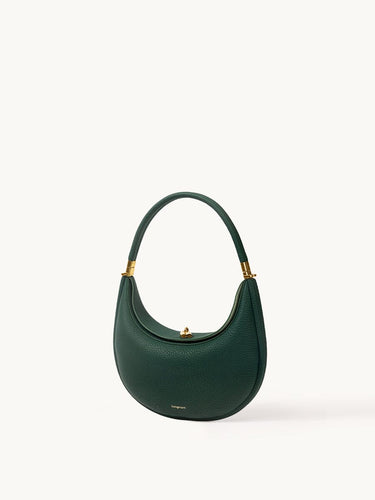 Emerald green Luna Bag in textured full-grain leather with gold hardware, showcasing a curved silhouette and elegant design.