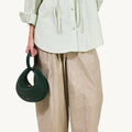 Emerald green pebbled leather Luna Bag with unique crescent shape and loop handle.