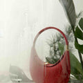Luna Bag in Lucky Red, textured cowhide leather, crescent shape with gold hardware.