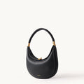 Black leather Luna Bag with gold hardware and curved handle.
