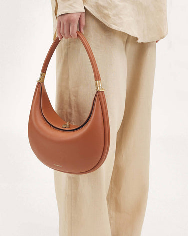 Luna Bag in Eco Caramel vegan leather with gold hardware. Adjustable strap for shoulder, crossbody, or hand carry.