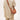A person wearing a neutral-toned outfit carries the Luna Bag in eco caramel vegan leather crossbody.