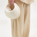 White vegan leather Luna Bag with gold hardware, made from recycled ocean plastic.