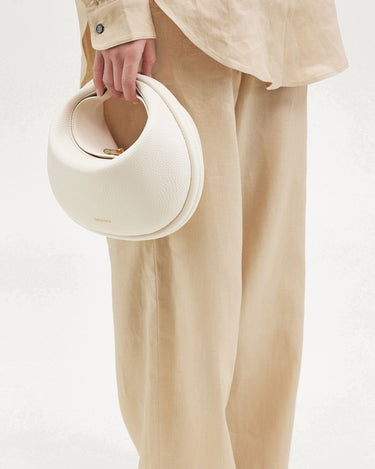 White vegan leather Luna Bag with gold hardware, made from recycled ocean plastic.