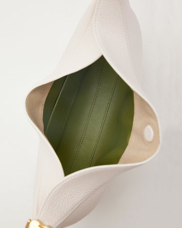 Open white vegan leather Luna Bag with green interior, showcasing texture and gold hardware.