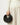 Black vegan leather Luna Bag with gold "Songmont" logo, crescent shape, on a person's hand.