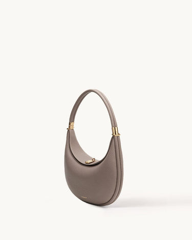 Luna Bag in taupe full-grain leather with gold-tone hardware and adjustable strap.