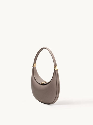 Luna Bag in taupe full-grain leather with gold-tone hardware and adjustable strap.