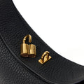 Black full-grain leather Luna Bag with open gold 'Songmont' clasp and hardware. Adjustable strap detail.