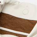 Cream leather bag interior with brown quilted lining, white trim, and embossed circle detail. Medium Gather Bag Set.